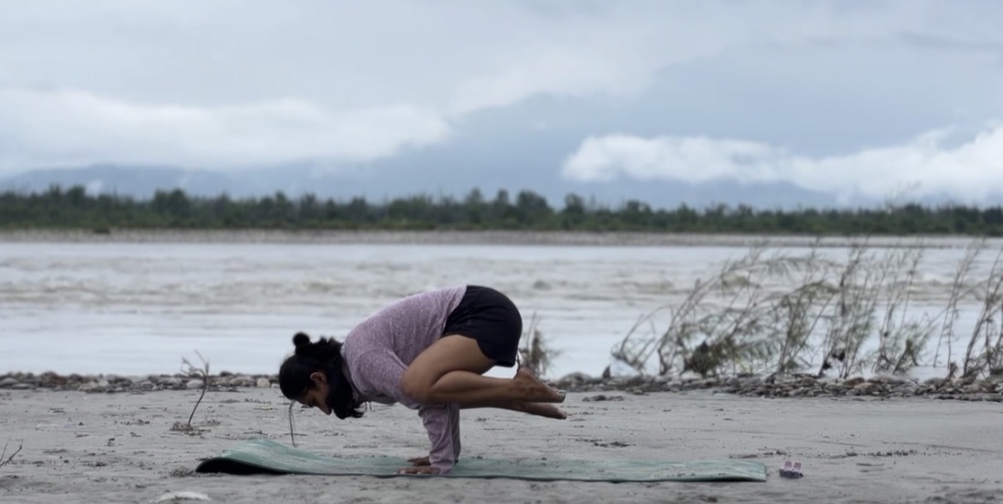 Crow pose on a mat by the river